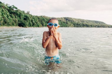 Sevimli komik Kafkas çocuk sualtı gözlükleri ile göl nehri yüzme. Sahilde suda çocuk dalışı. Otantik gerçek yaşam tarzı mutlu çocukluk. Yaz eğlencesi açık su aktivitesi.