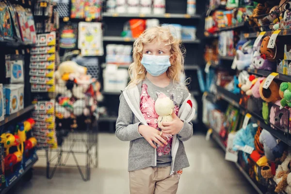新しい常態だ おもちゃ屋で衛生面マスクショッピングで白人ブロンドの女の子 コロナウイルスから身を守るマスクをした子供 Covid 19検疫中の安全性 健康保護 — ストック写真