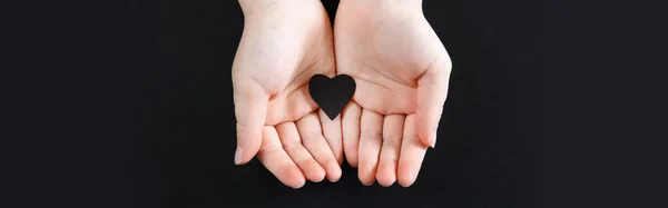 Χέρια Που Κρατούν Μαύρη Χάρτινη Καρδιά Σκούρο Φόντο Υποστήριξη Του — Φωτογραφία Αρχείου