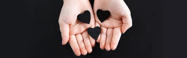 Χέρια Που Κρατούν Μαύρες Χάρτινες Καρδιές Σκούρο Φόντο Υποστήριξη Του — Φωτογραφία Αρχείου