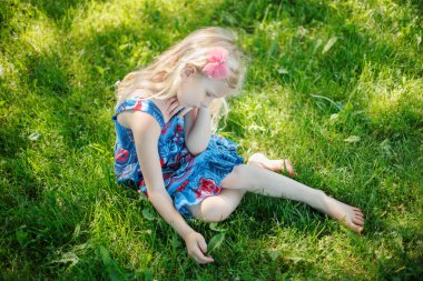 Üzgün genç kız yaz güneşli bir günde açık havada oturuyor. Düşünceli küçük çocuk hayal kuruyor. Stres sorunlarıyla başa çıkmaya çalışan güvensiz yalnız bir çocuk. Otantik çocukluk yaşam tarzı.