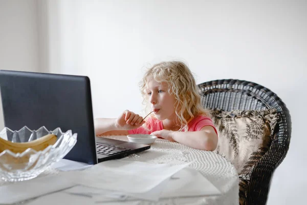 Młoda Dziewczyna Jedzenie Ogląda Kreskówki Laptopie Dziecko Cyfrowym Gadżetem Podczas — Zdjęcie stockowe