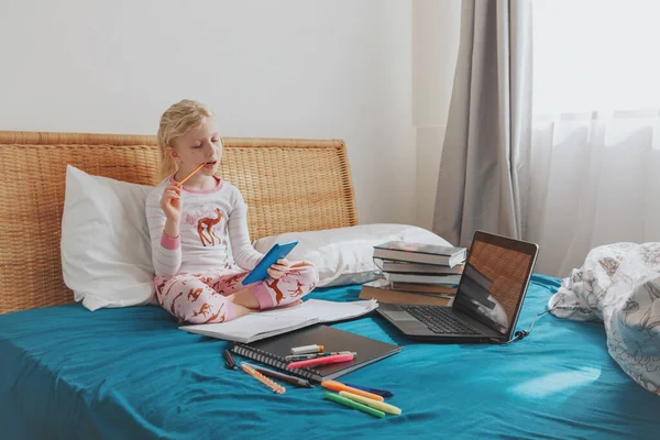 白人女童坐在床上 靠计算器在网上学习 在家中自我隔离期间的虚拟视频课程 远程视频教育 新的儿童师范学校 — 图库照片