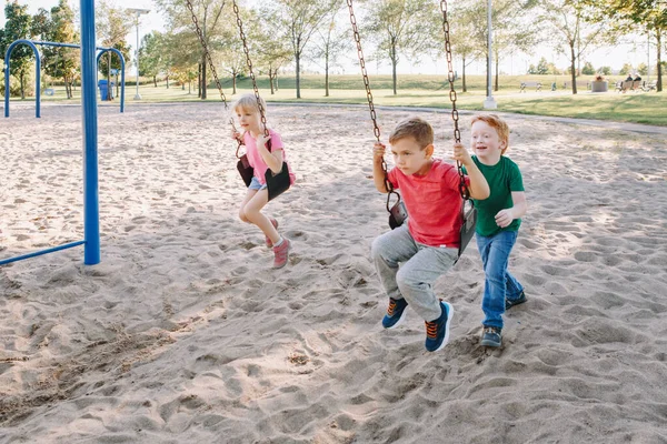 Feliz Sorrindo Pequenos Amigos Pré Escolares Balançando Balanços Playground Fora — Fotografia de Stock