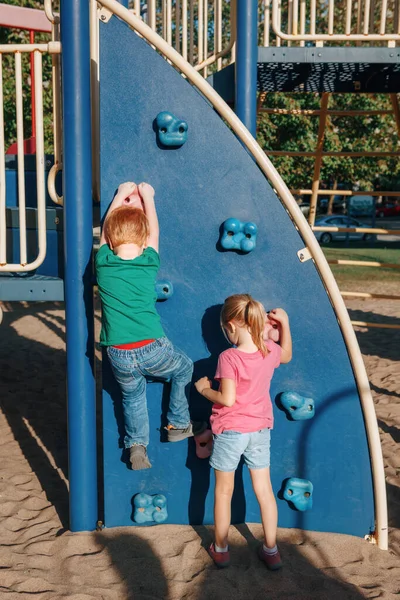 Liten Förskolekille Och Flicka Klättrar Bergvägg Lekplatsen Utanför Sommardagen Glad — Stockfoto