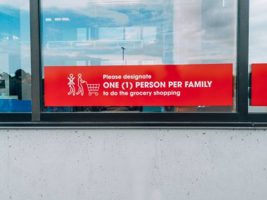 Toronto, Ontario, Kanada - 16 Ağustos 2020: Market vitrininde her aile için market alışverişi için bir kişi belirleme uyarısı. Coronavirus covid-19 'a karşı güvenlik önlemleri.