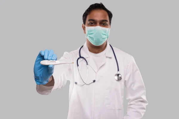 Doctor Showing Thermometer Het dragen van medische masker en handschoenen geïsoleerd. Indiase man dokter met thermometer in handen. Gezond leven, dokter, Virus Concept — Stockfoto