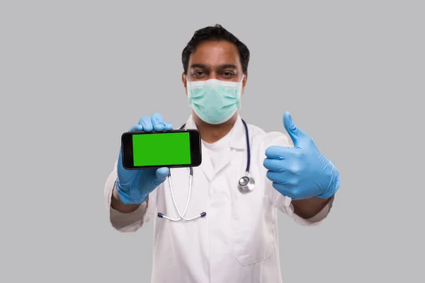 Doctor Showing Phone and Thumb Up Wearing Medical Mask and Gloves. Indian Man Doctor Technology Medicine at Home. Phone Green Screen Close Up Isolated — Stock Photo, Image