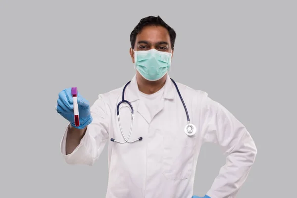 Indian Man Doctor drží krevní trubice analýzy na sobě lékařské masky a rukavice. Věda, lékařská koncepce. Izolované. — Stock fotografie