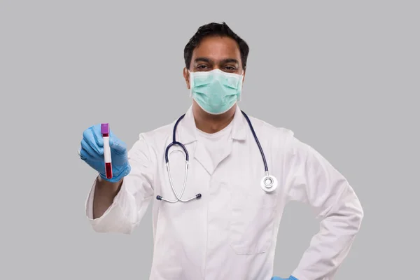 Médico indiano segurando análise de tubo de sangue vestindo máscara médica e luvas. Ciência, Conceito Médico. Isolados . — Fotografia de Stock