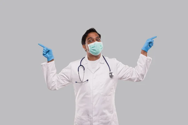 Indian Man Doctor Pointing to Sides both Hands Wearing Medical Mask and Gloves. Isolated — Stock Photo, Image