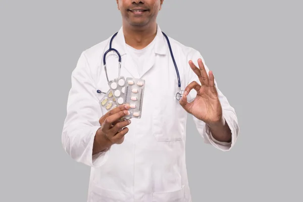 Mann Doktor zeigt Pillen und OK Sign Close Up. Doktor hält Tabletten. Indischer Arzt isoliert. — Stockfoto