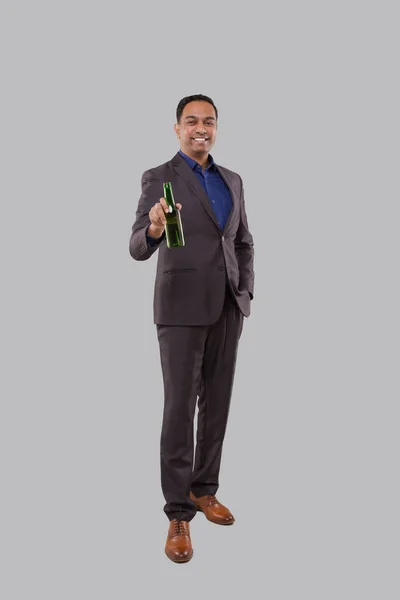 Zakenman die bierflesje vasthoudt. Indiase zakenman staande volledige lengte. — Stockfoto