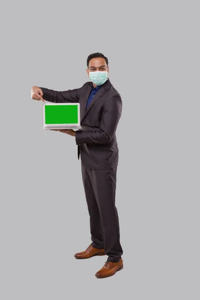 Affärsman Peka på Laptop Grön skärm Isolerad bär Medical Mask och handskar. Indiska affärsman med laptop i händerna. Affärsidé online — Stockfoto