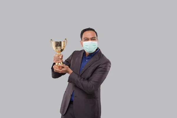 Affärsman som håller Trophy bär medicinsk mask. Indian Business man Stående med trofé i händerna — Stockfoto
