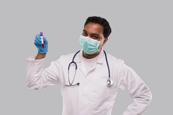 Indischer Arzt mit Blutröhrenanalyse trägt medizinische Maske und Handschuhe. Wissenschaft, medizinisches Konzept. Isoliert. — Stockfoto