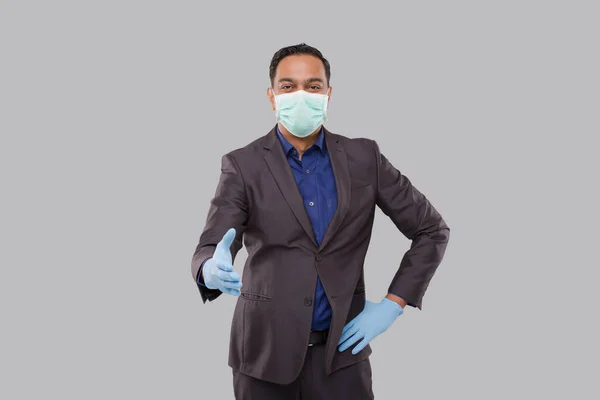 Indian Businessman offering hand to shake Wearing Medical Mask and Gloves. Greeting and welcoming gesture. Business advertisement concept. Businessman Hand Shake. Sign