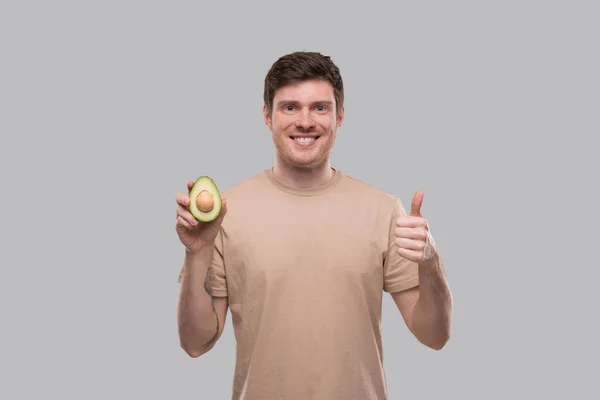 Man Toont Avocado Thumb Geïsoleerd Avocado Doormidden Gesneden Voedsel — Stockfoto