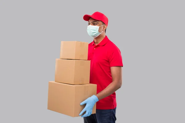 Entrega Hombre Sosteniendo Cajas Cartón Usando Máscara Médica Guantes Mirando — Foto de Stock