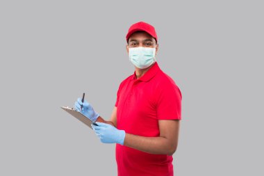 Teslimatçı, tıbbi maske ve eldiven takıp kameraya yazı yazıyor. Hint Teslimatçı Çocuk Panosu. Erkek
