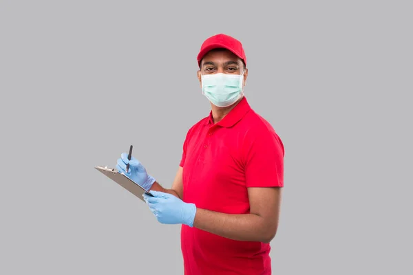 Delivery Man Skriva Urklipp Bär Medicinsk Mask Och Handskar Titta — Stockfoto