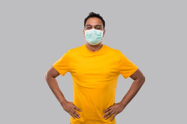 Indiai férfi kezek oldalra viselt orvosi maszk sárga pólóban izolált — Stock Fotó