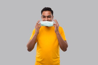 Hintli Adam Sarı Tişörtle Tıbbi Maske Giyiyor