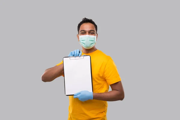 Indian Man håller urklipp bär medicinsk mask och handskar titta i kameran. Indiska leverans pojke Urklipp — Stockfoto