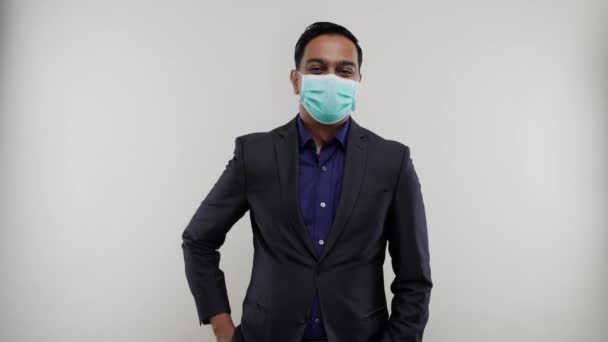Affärsman visar fred tecken bär medicinsk mask. Indiska affärsman tecken isolerad — Stockvideo
