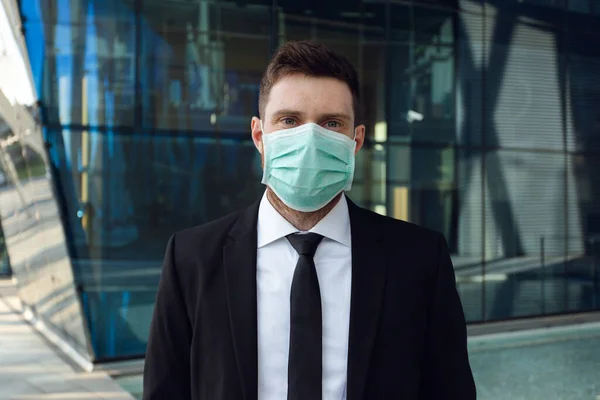 Affärsman bär medicinsk mask i Business Center. Affärsman i svart kostym — Stockfoto