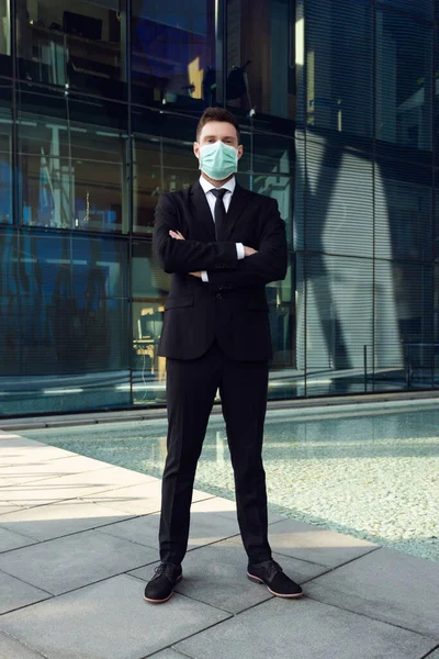 Affärsman bär medicinsk mask i Business Center Hands Crossed. Affärsman i svart kostym — Stockfoto