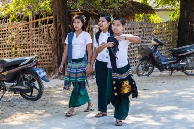 Ngapali Beach, Myanmar - 3 Aralık 2014: Ngapali beach otelleri güneyinde balıkçı köyü yeşim Taw, okulda okul üç küçük kız gitmek.