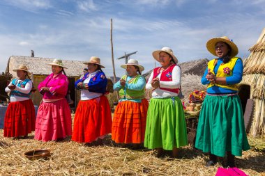 Puno, Peru - 27 Eylül 2018: Peru 'daki Peru ve Bolivya arasındaki sınırda Uros Süzülen Adaları' nda geleneksel giysiler içindeki kadınlar