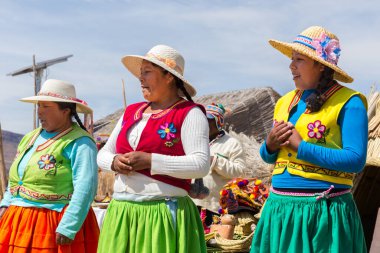 Puno, Peru - 27 Eylül 2018: Peru 'daki Peru ve Bolivya arasındaki sınırda Uros Süzülen Adaları' nda geleneksel giysiler içindeki kadınlar