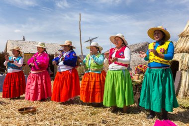 Puno, Peru - 27 Eylül 2018: Peru 'daki Peru ve Bolivya arasındaki sınırda Uros Süzülen Adaları' nda geleneksel giysiler içindeki kadınlar