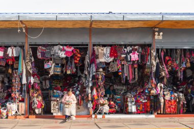 Puno, Peru - 27 Eylül 2018: Peru, Puno 'da el yapımı alpaka ürünleri satan bir hediyelik eşya dükkanı işleten kadın.
