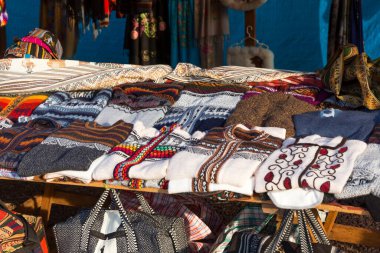 Peru 'da, Puno yakınlarındaki Umayo Gölü kıyısındaki Sillustani arkeolojik sahasında el yapımı alpaka tekstil ürünleri satan bir el işi pazarı.