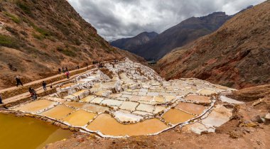 Maras, Peru - Ekim 05, 2018: Maras, Peru 'daki Salt Pond' daki insanlar. İnka öncesinden beri, yerel bir yeraltı deresinden tuzlu suyu buharlaştırarak Maras 'ta tuz elde edilmiştir..