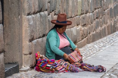 Cusco, Peru - Ekim 08, 2018: Geleneksel yerli giysili Quechua kadınları renkli tekstil satarak yerel el sanatları hediyelik eşyaları yapıyorlar