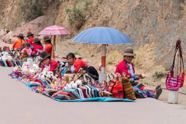 Pisac, Peru - Ekim 09, 2018: Geleneksel yerli giysili Quechua kadınları renkli tekstil satarak yerel el sanatları hediyelik eşyaları yapıyorlar