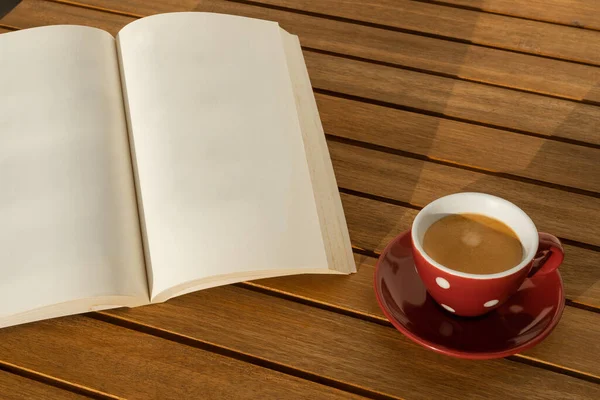 Ahşap bir masada boş bir kitap ve kahve fincanı. Bağlantıyı kesme anı.