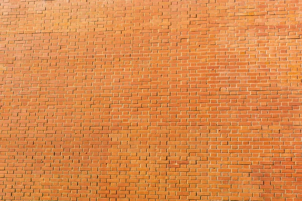 Orange bricks wall texture background. Structure of small stones wallpaper. Outside stone wall surface. Vintage brick wall with grunge stonework. Urban brown exterior of tiled brickwork with copyspace