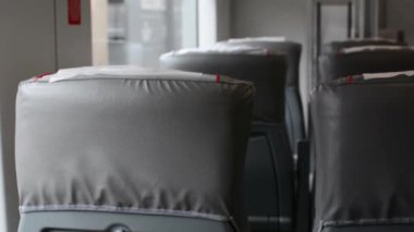 Gri tren koltukları ve katlanan masalar arasında arka plan. Kamu treninin arka planında bulanık yeni bir iç mekan. Yolcu taşımacılığının plastik koltukları. Bir sıra rahat turist koltuğu..