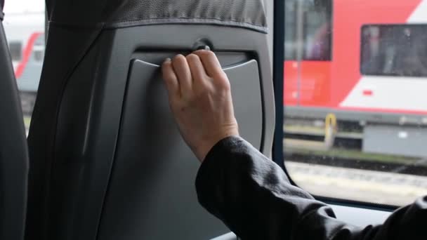 Kvinnas Hand Öppnar Spärren Ett Fällbart Sittbord Ett Stadståg Passageraren — Stockvideo