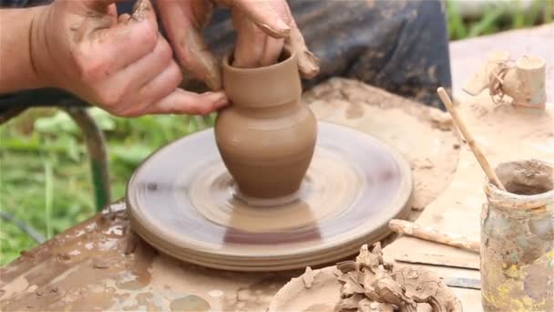 Manos moldeando una olla de barro en la rueda de cerámica . — Vídeo de stock