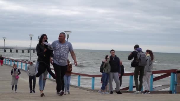 Palanga, Lituania - 1 luglio 2018. Ponte del Mare di Palanga. Persone che camminano su un ponte verso il mare. Costa sabbiosa del Mar Baltico . — Video Stock