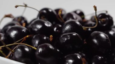 Kiraz. Olgun kiraz beyaz arka plan üzerinde döner. Dönen siyah Olgun tatlı kiraz. Döndürme 4k Uhd video. Döngü sorunsuz imkanı. Closeup Makro.