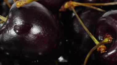 Kiraz. Olgun kiraz siyah arka plan üzerinde döner. Dönen siyah Olgun tatlı kiraz. Döndürme 4k Uhd video. Döngü sorunsuz imkanı. Closeup Makro.