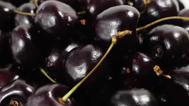 Cherry. Ripe cherries rotating over black background. Rotating Black Ripe Sweet Cherry. Rotation 4K UHD video. Seamless looping. Closeup Makro. — Stock Video