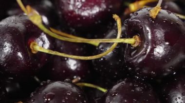 Kiraz. Olgun kiraz siyah arka plan üzerinde döner. Dönen siyah Olgun tatlı kiraz. Döndürme 4k Uhd video. Döngü sorunsuz imkanı. Closeup Makro.